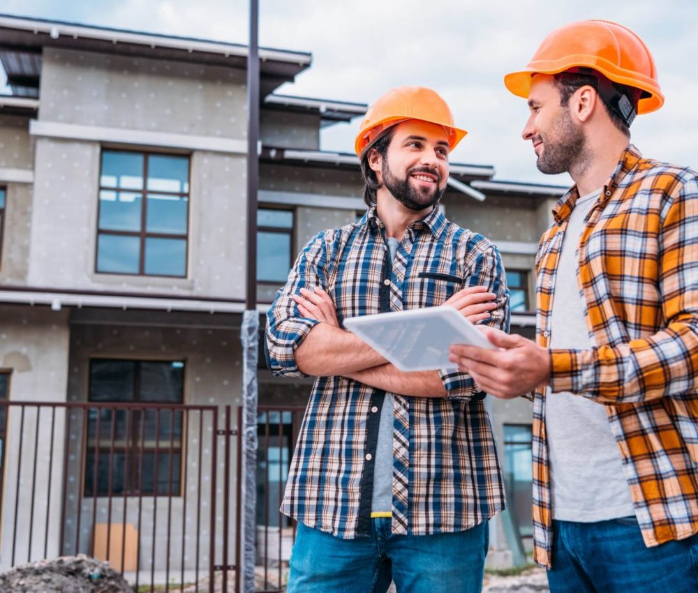 happy-architects-using-digital-tablet-at-construction-site-1.jpg